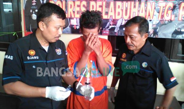 Tersangka Arif bersama petugas Polres Tanjung Perak. foto: ekoyono/ BANGSAONLINE