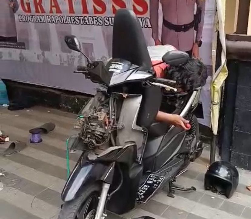 Teknisi Polsek Bubutan saat memasangkan alarm anti maling ke motor warga