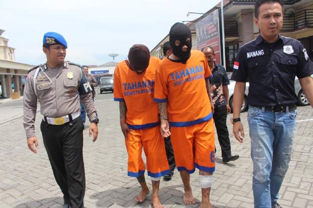 Kedua tahanan dengan bekas tembakan di kakinya saat dikawal petugas. (foto:andi catur erlambang/HARIAN BANGSA)
