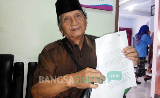 Ibnu Sulkan tengah membeber surat desakan ganti rugi. foto: YUDI EP/ BANGSAONLINE