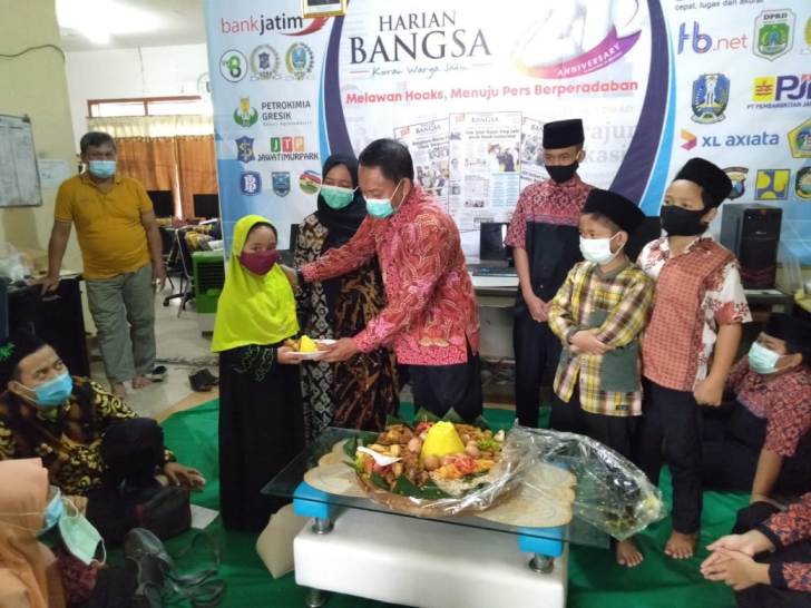 M Mas’ud Adnan, Komisaris Utama HARIAN BANGSA memberikan potongan pucuk tumpeng HUT ke-21 HARIAN BANGSA kepada anak yatim dari Panti Asuhan Al-Jihad Jemursari Surabaya  di Kantor HARIAN BANGSA Jalan Gayungsari Surabaya, Senin (1/3/2021). Foto: Nur Syaifuddin/ BANGSAONLINE.COM