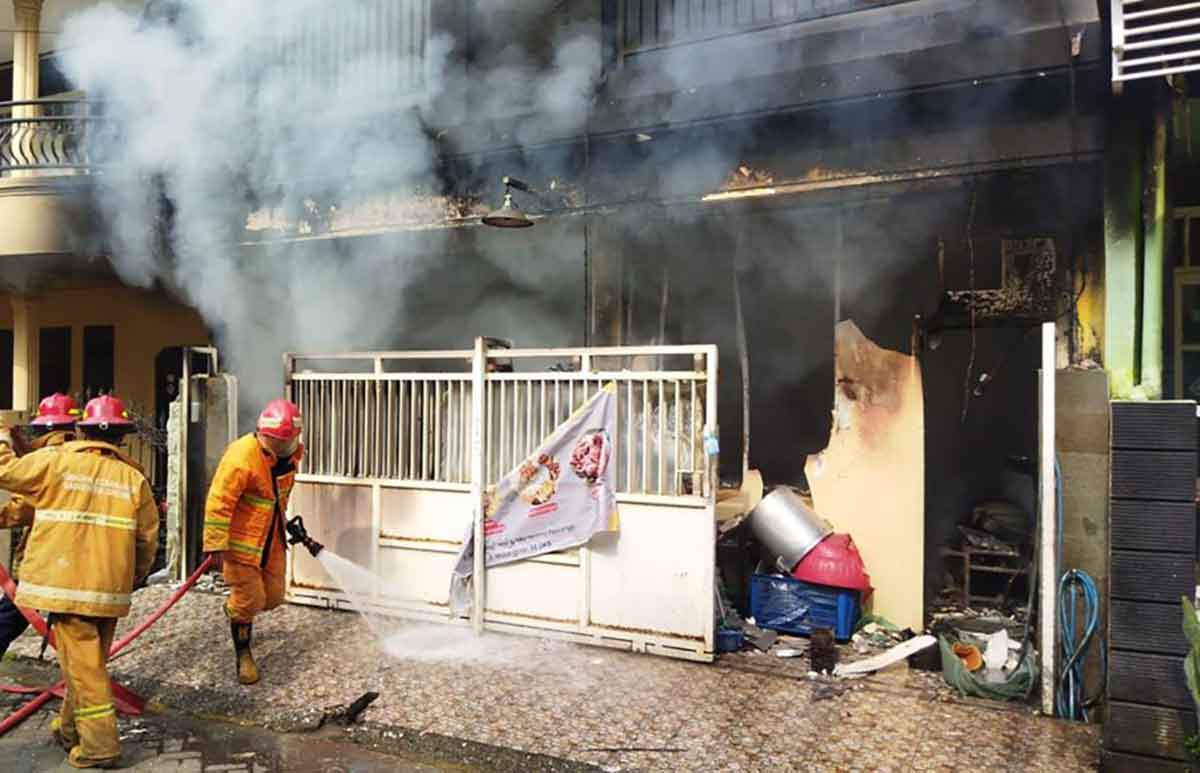 Petugas Damkar Pemkab Gresik saat melakukan pemadaman. Foto: SYUHUD/BANGSAONLINE.com