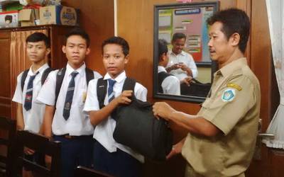 Pelajar mengembalikan tas yang ditemukannya. foto:aris sugiarto/BANGSAONLINE