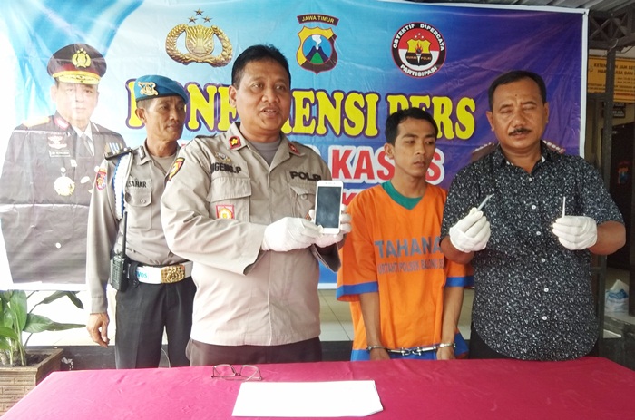 Kapolsek Balongbendo Kompol Sugeng Purwanto sedang menunjukkan barang bukti berupa handphone milik tersangka.