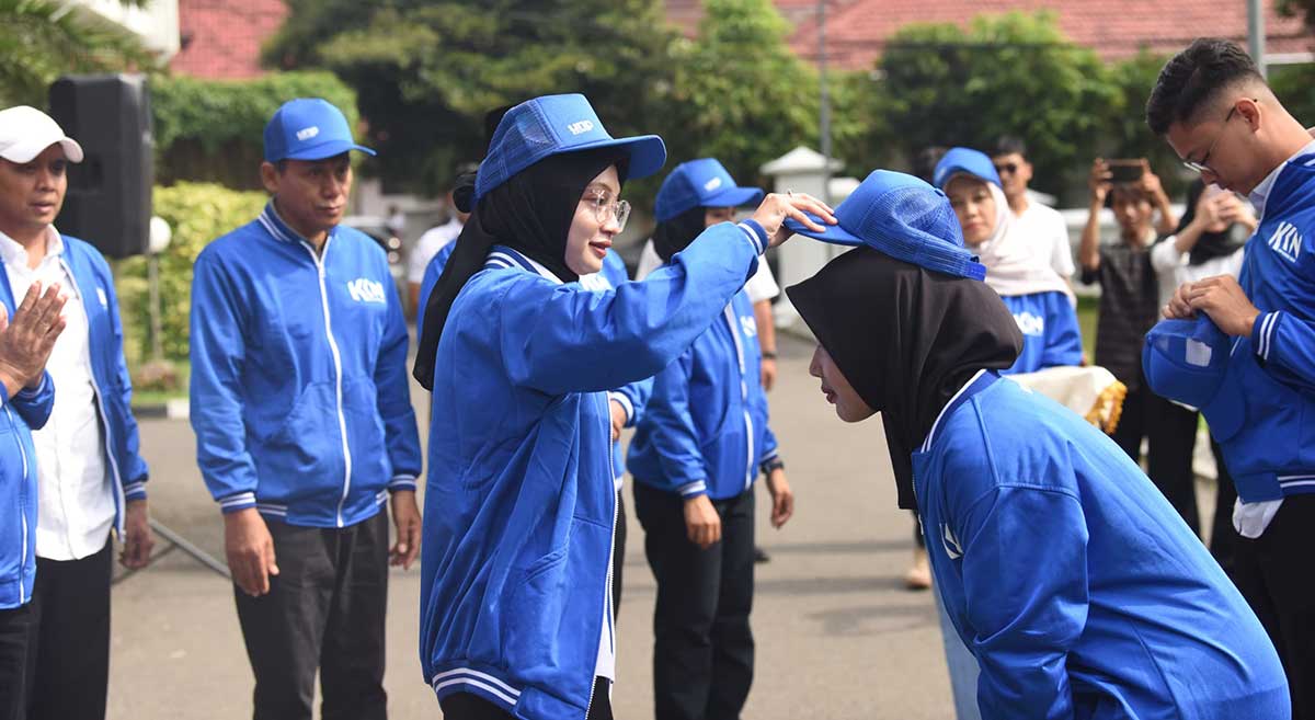 Wali Kota Kediri saat mengenakan topi kepada salah satu mahasiswi UN PGRI yang akan mengikuti KKN Tematik. Foto: Ist