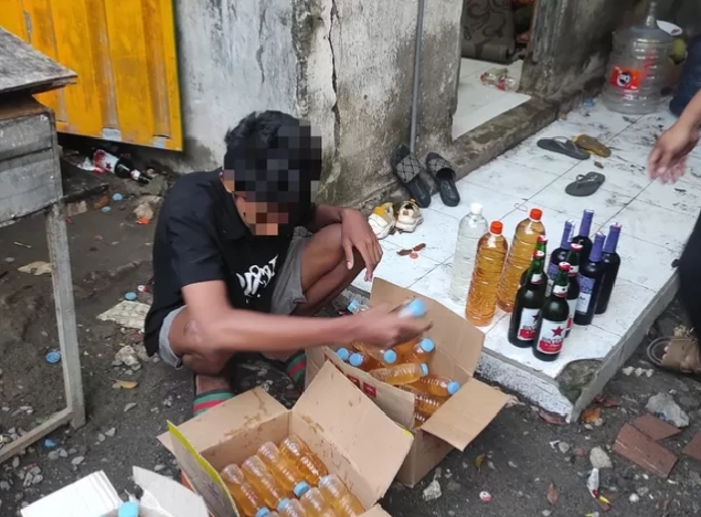 Salah satu penjual miras beserta barang bukti yang diamankan