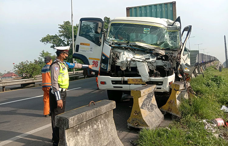 Petugas saat mengevakuasi truk yang terlibat kecelakaan di Jalan Tol Sidoarjo menuju arah Porong.