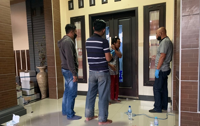 Petugas kepolisian saat melakukan olah TKP di rumah korban.