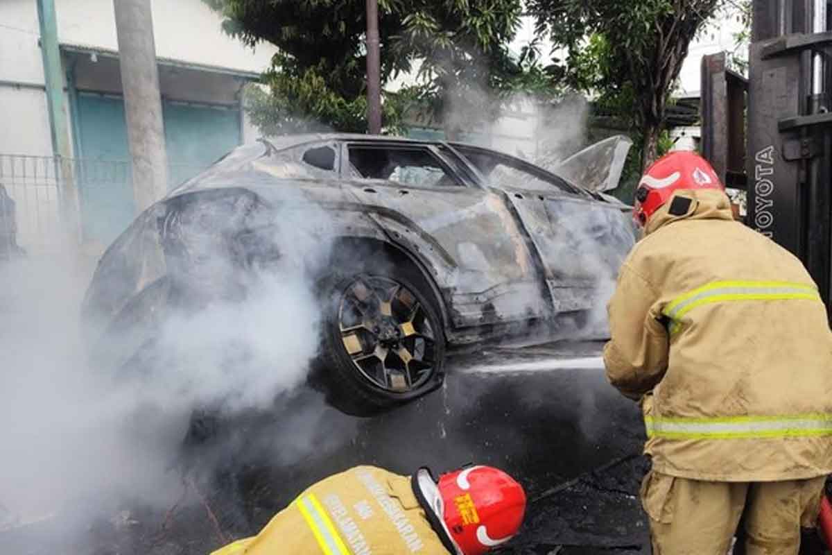 Petugas Dinas Pemadam Kebakaran dan Penyelamatan (Damkar) Gresik saat melakukan pemadaman api pada mobil Hyundai Kona. Foto: Ist.
