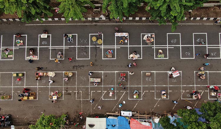 Penerapan physical distancing kepada para pedagang di Pasar Pegirian. (foto: ist).