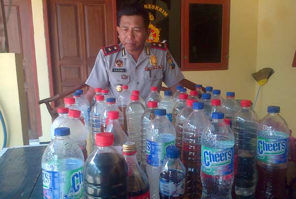 MIRAS. Kapolsek Kota Bojonegoro, Kompol Saibani saat menunjukan barang bukti puluhan liter miras hasil sitaan selama lima hari. Foto: Eky Nurhadi/BANGSAONLINE