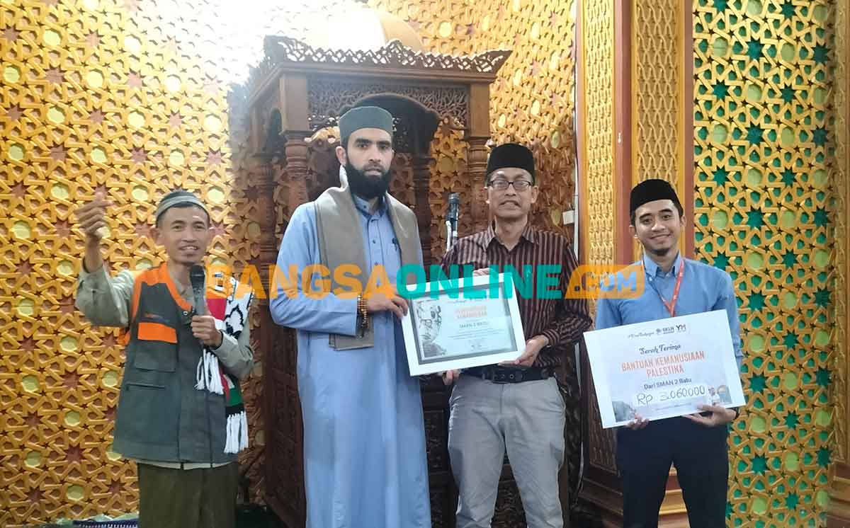 Kepala Satuan Pendidikan SMAN 2 Batu, Anto Dwi Cahyono, saat foto bersama usai menyerahkan donasi untuk warga Palestina. Foto: AGUS SALIMULLAH/BANGSAONLINE