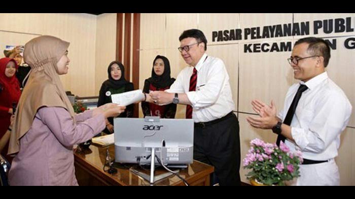 Mendagri Tjahjo Kumolo saat memberikan dokumen pengurusan ke warga di kantor pasar pelayanan publik.