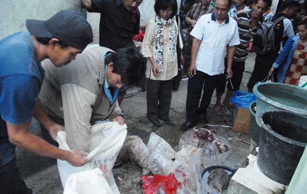 Tampak petugas saat memeriksa daging milik salah satu penjual di Pasar Ploso Jombang. (foto: rony suhartomo/BANGSAONLINE)