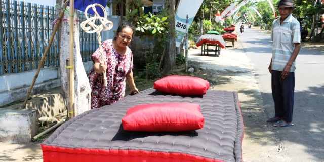 Warga Using Kemiren kompak mepe (menjemur) kasur di sepanjang jalan desa setempat. 