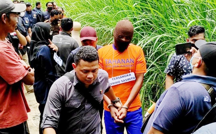 Tersangka saat melakukan rekonstruksi dengan kawalan ketat petugas. foto: ist.