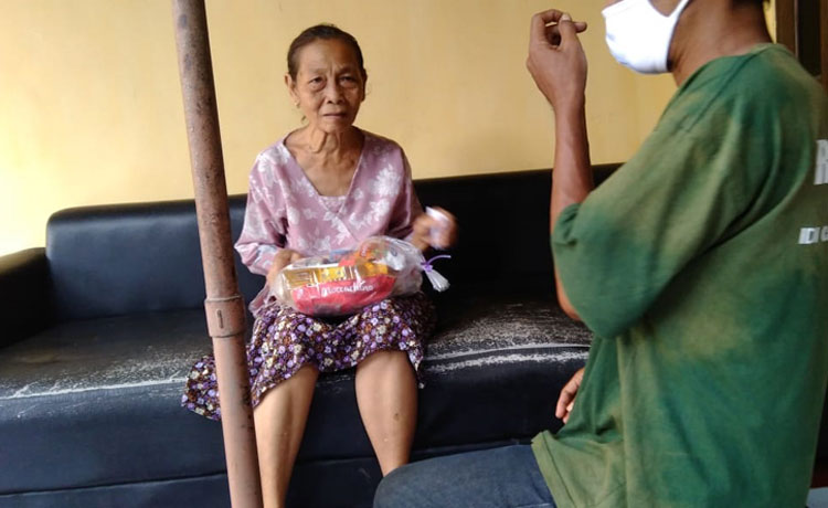 Antok Beler, Ketua Gusdurian Mojokutho saat menyerahkan bantuan berupa uang dari dermawan kepada Mbah Jini, Jumat (15/5). 