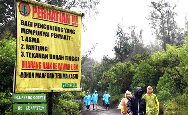 Sejumlah wisatawan menggunakan jas hujan saat mendaki di Gunung Ijen, Banyuwangi, Rabu (27/7). Meski hujan selama beberapa hari di kawasan Gunung Ijen menyebabkan meningkatnya volume gas belerang, namun wisatawan lokal dan asing tetap ramai. 