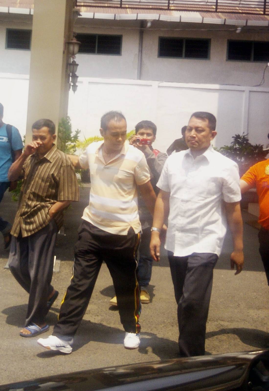 DITAHAN – Achmad Zainudin saat menuju mobil tahanan Kejari Mojokerto yang siap mengantar ke LP Taman Siswa, Jumat (5/9/2014). foto : agus/BangsaOnline