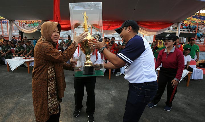 Camat Tambaksari, Ridwan Mubarun menyerahkan piala bergilir juara umum ke Wali Kota Risma.