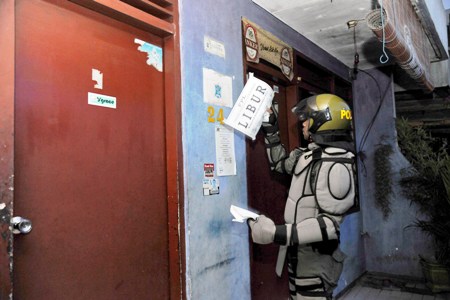 petugas  mencopoti atribut dan tulisan libur yang ditempel di setiap wisma. foto:humas