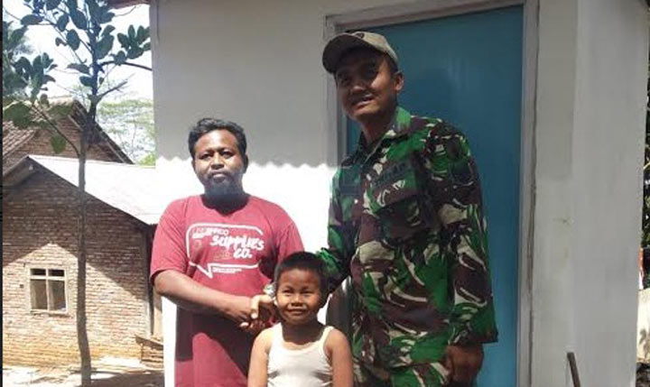 Serma Yolla Babinsa Desa Kedungsalam bersama salah satu warga yang menerima bantuan jamban.