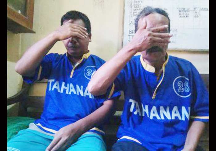 Dua pelaku yang diamankan petugas sedang menutupi wajahnya.