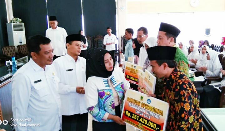 Wali Kota Mojokerto Ning Ita menyerahkan bantuan pendidikan bagi 12 mahasiswa berprestasi, honorarium 116 GTT-PTT, dan BOB Madin Madrasah di Kota Mojokerto. Ia meyakinkan bantuan akan berkelanjutan. foto: YUDI EP/ BANGSAONLINE 