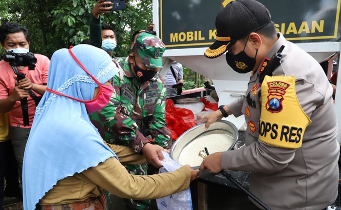 Kapolres Mojokerto sedang memberikan bantuan beras kepada salah satu warga.