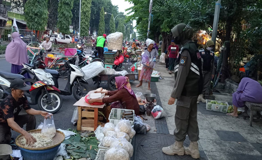 Petugas satpol PPsaat menertibkan para pedagang yang berjualan di trotoar depan Pasar Baru Gresik. Foto: SYUHUD/ BANGSAONLINE