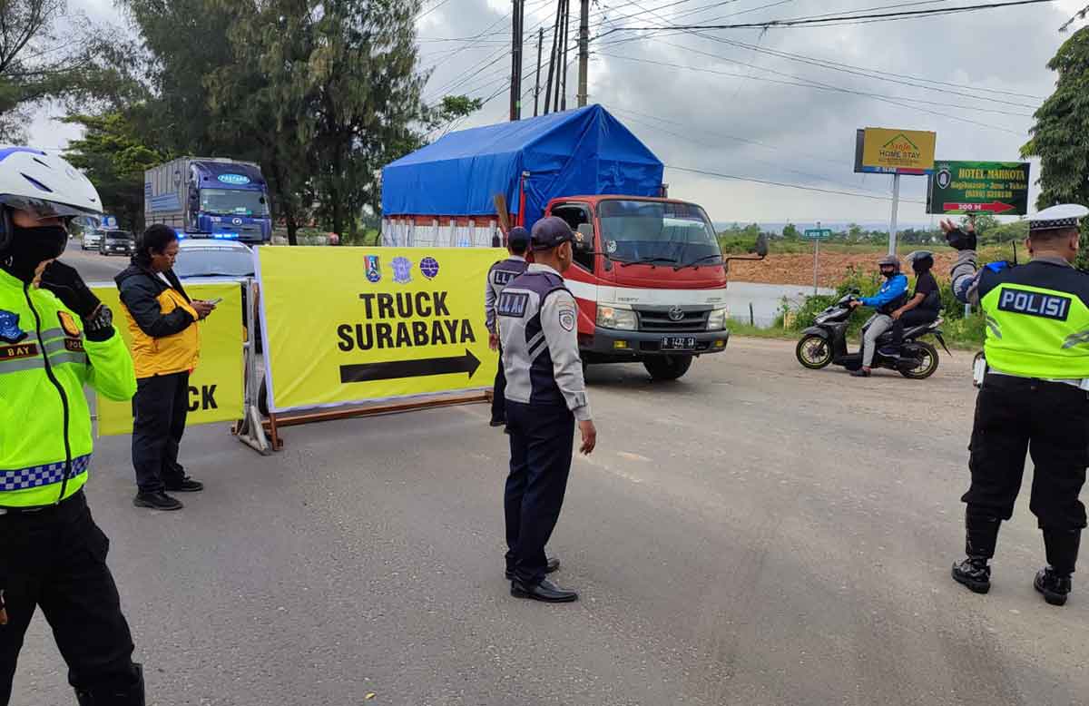 Petugas saat mengalihkan arus kendaraan bermuatan berat.