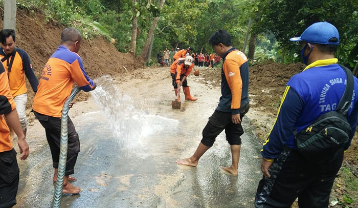 TRC BPBD Pamekasan bersama TNI-Polri dan relawan saat membuka akses jalan yang tertutup longsor. 