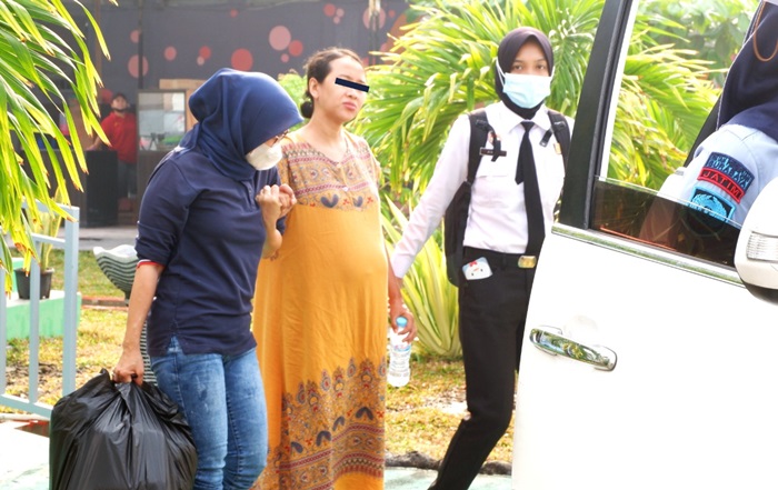 Tampak seorang petugas perempuan berusaha membopong AV dari belakang. Petugas lainnya membantu membawakan perlengkapan dan pakaian milik AV. 