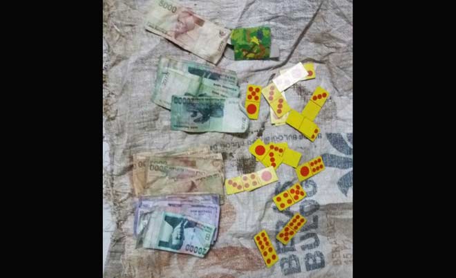 Barang bukti berupa uang dan kartu domino saat diamankan.