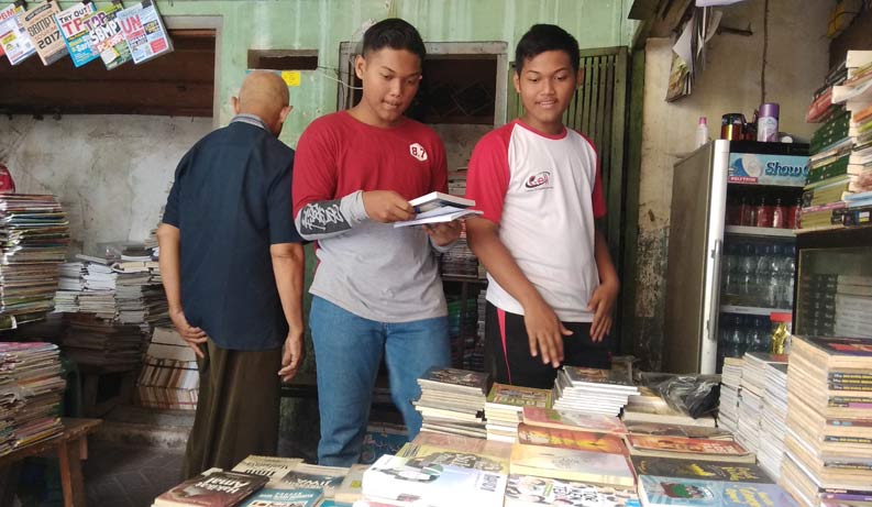 Pembeli sedang mencari buku yang hendak dibeli.