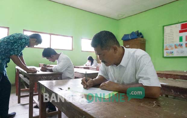 Ali Sutikno, serius mengerjakan UN paket A. foto: rony suhartomo/ BANGSAONLINE