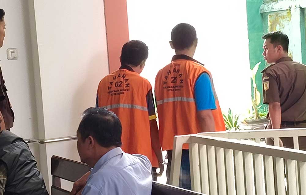 Kedua terdakwa saat digiring petugas ke ruang tahanan PN Kota Kediri. Foto: MUJI HARJITA/ BANGSAONLINE