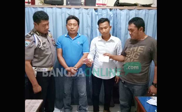 Dua tersangka pemerasan, Santoso dan Dedi Suwanto, saat diamankan di Mapolsek Cerme. foto: SYUHUD/ BANGSAONLINE