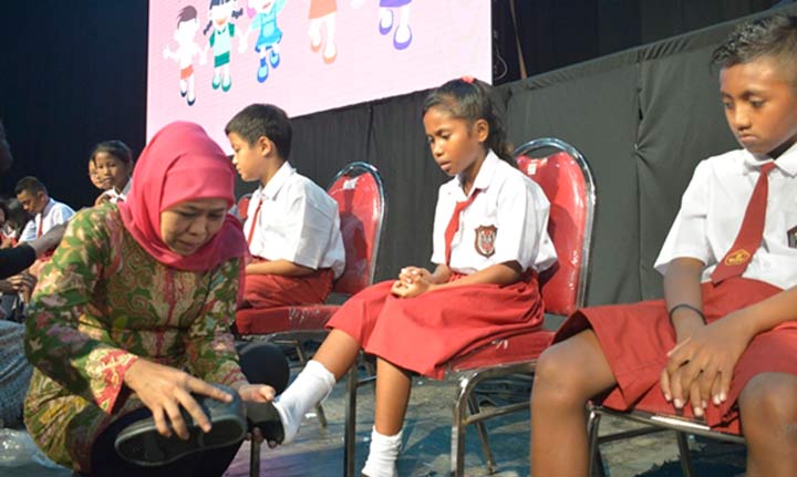 Gubernur Khofifah berkesempatan membagikan secara langsung dan ikut memakaikan sepatu pada perwakilan anak-anak yang hadir. foto: ist
