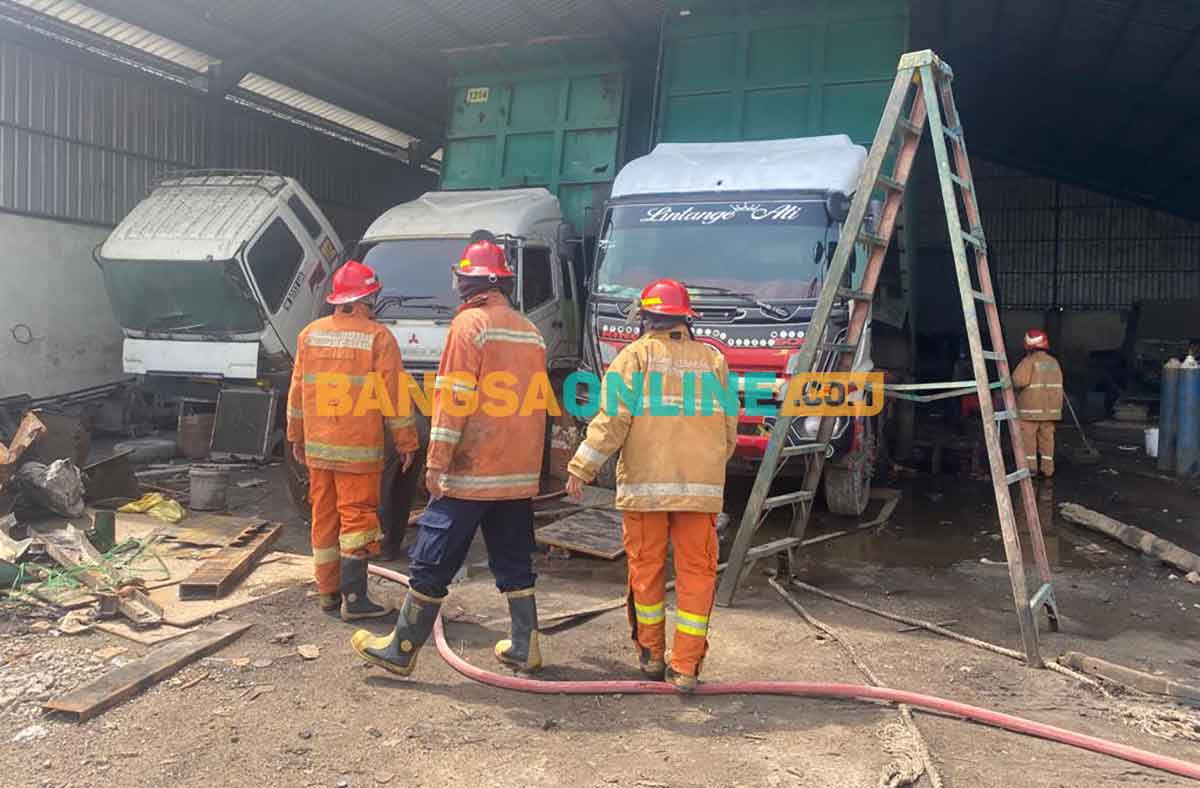 Petugas Damkar Gresik saat melakukan pemadaman kebakaran di bengkel PT Yani Putra. Foto: SYUHUD/BANGSAONLINE

