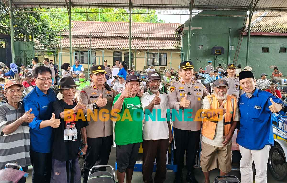 Kapolres Kediri, AKBP Bimo Arianto, didampingi Ketua PWI Kediri, Bambang Iswahjoedi, saat menyerahkan bantuan secara simbolis kepada salah satu tukang becak. Foto: MUJI HARJITA/BANGSAONLINE
