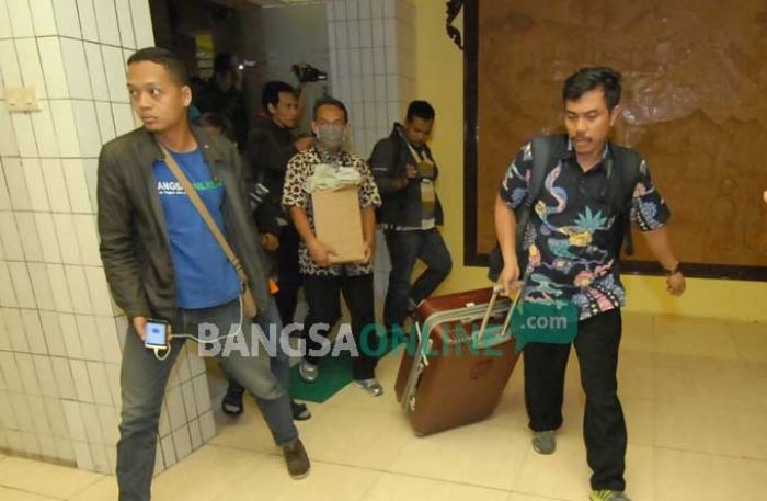 Petugas KPK membawa koper besar berisi dokumen saat keluar dari ruang kerja Sekda Jombang, Ita Triwibawati, Senin (5/11). foto: RONY S/ BANGSAONLINE