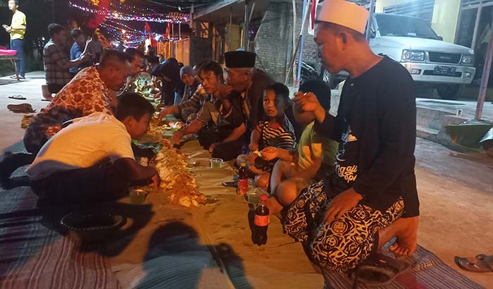 Suasana saat 800 warga makan bersama di atas daun pisang sepanjang 777 meter.
