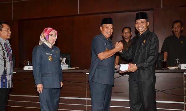 Bupati Lamongan, Fadeli menyerahkan LKPJ kepada Ketua DPRD Kaharudin. foto: nurqomar/ BANGSAONLINE