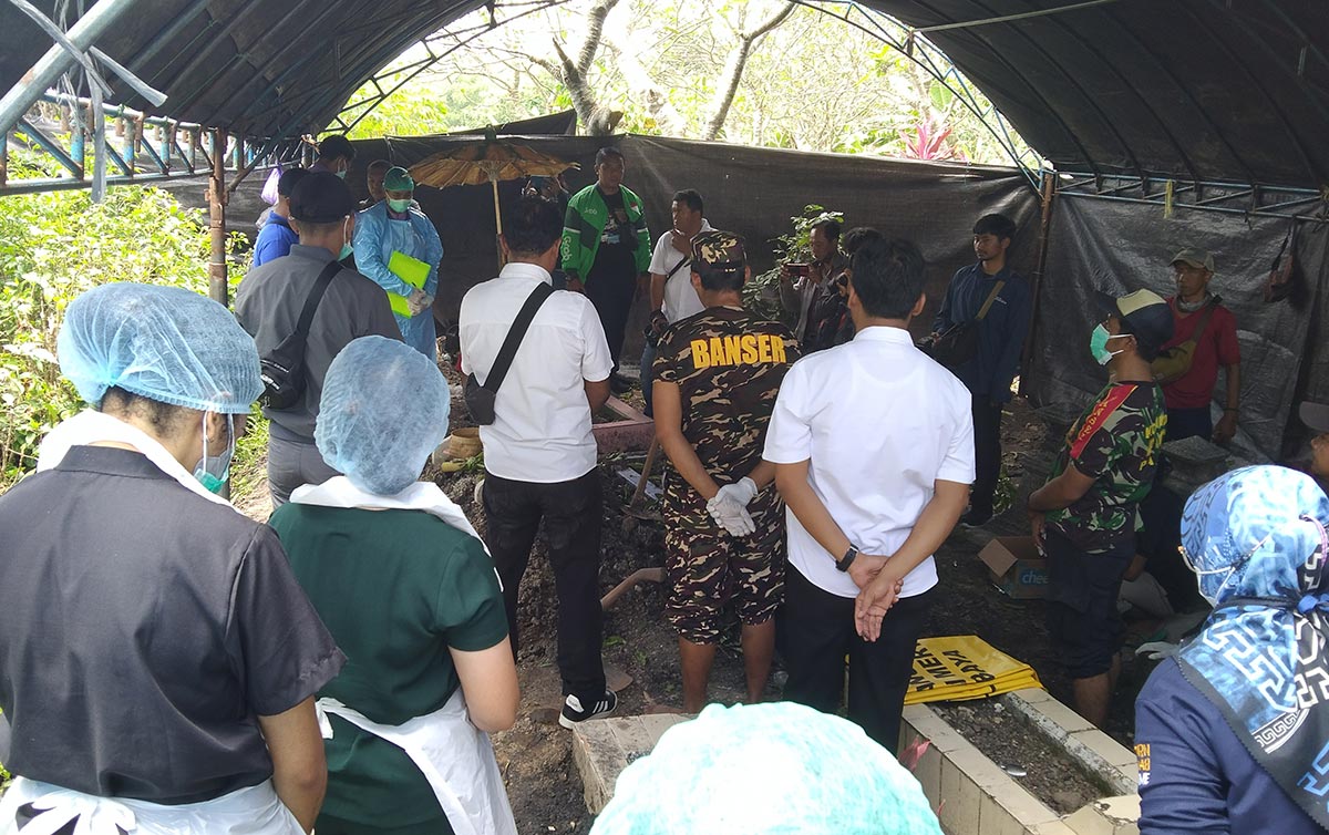 Polisi saat membongkar makam korban untuk keperluan autopsi jenazah.