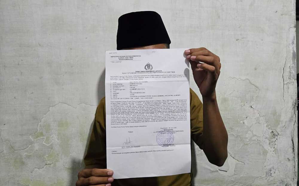 Korban AF, seorang mahasiswa UIN Madura menunjukkan bukti laporan polisi usai dikeroyok sesama mahasiswa. Foto: DIMAS M. S./ BANGSAONLINE