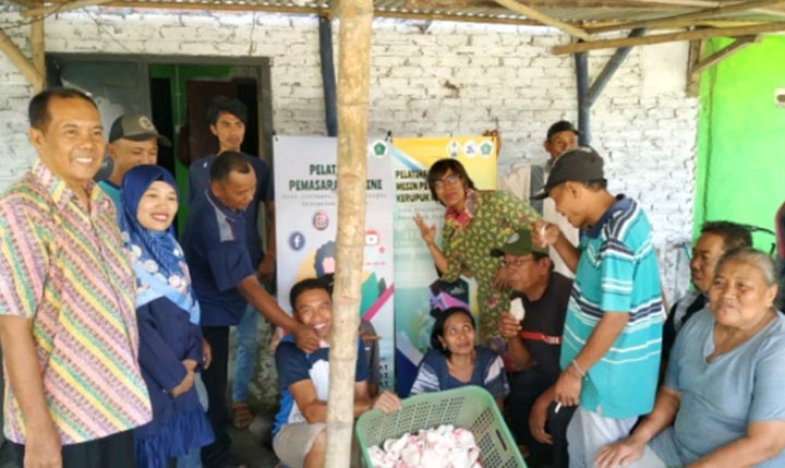 Para pelaku UMKM Kerupuk Melarat foto bersama tiga dosen Universitas PGRI Adi Buana Surabaya usai mendapatkan pelatihan menggunakan mesin pengering elektrik.
