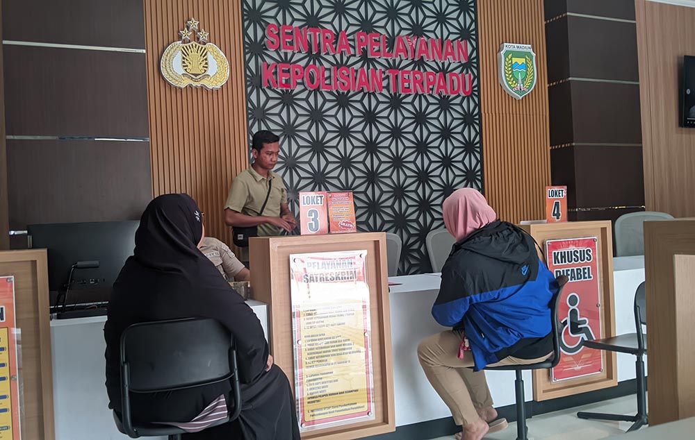 AA didampingi rekannya saat melaporkan sang suami ke Polres Madiun Kota. Foto: HENDRO SUHARTONO/ BANGSAONLINE