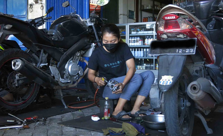Mutia Anjar Wasih saat bekerja di bengkel. (foto: ist)