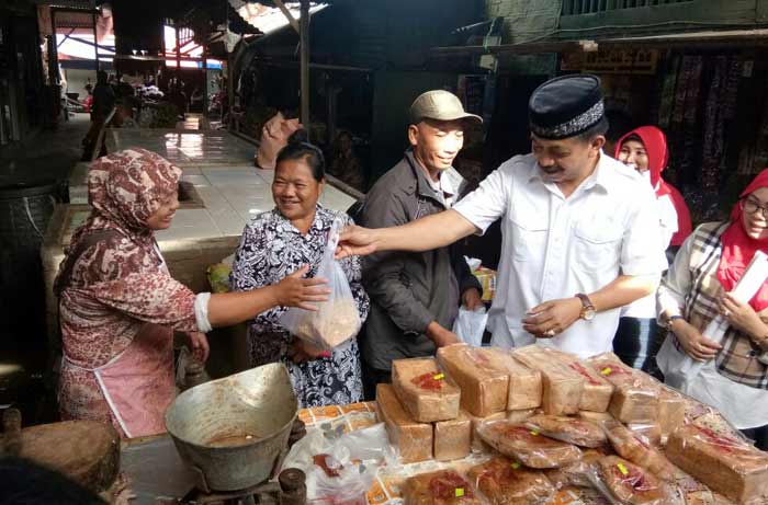 Gus Syaf memborong kue di lapak milik Pak Wagino. foto: BANGSAONLINE
